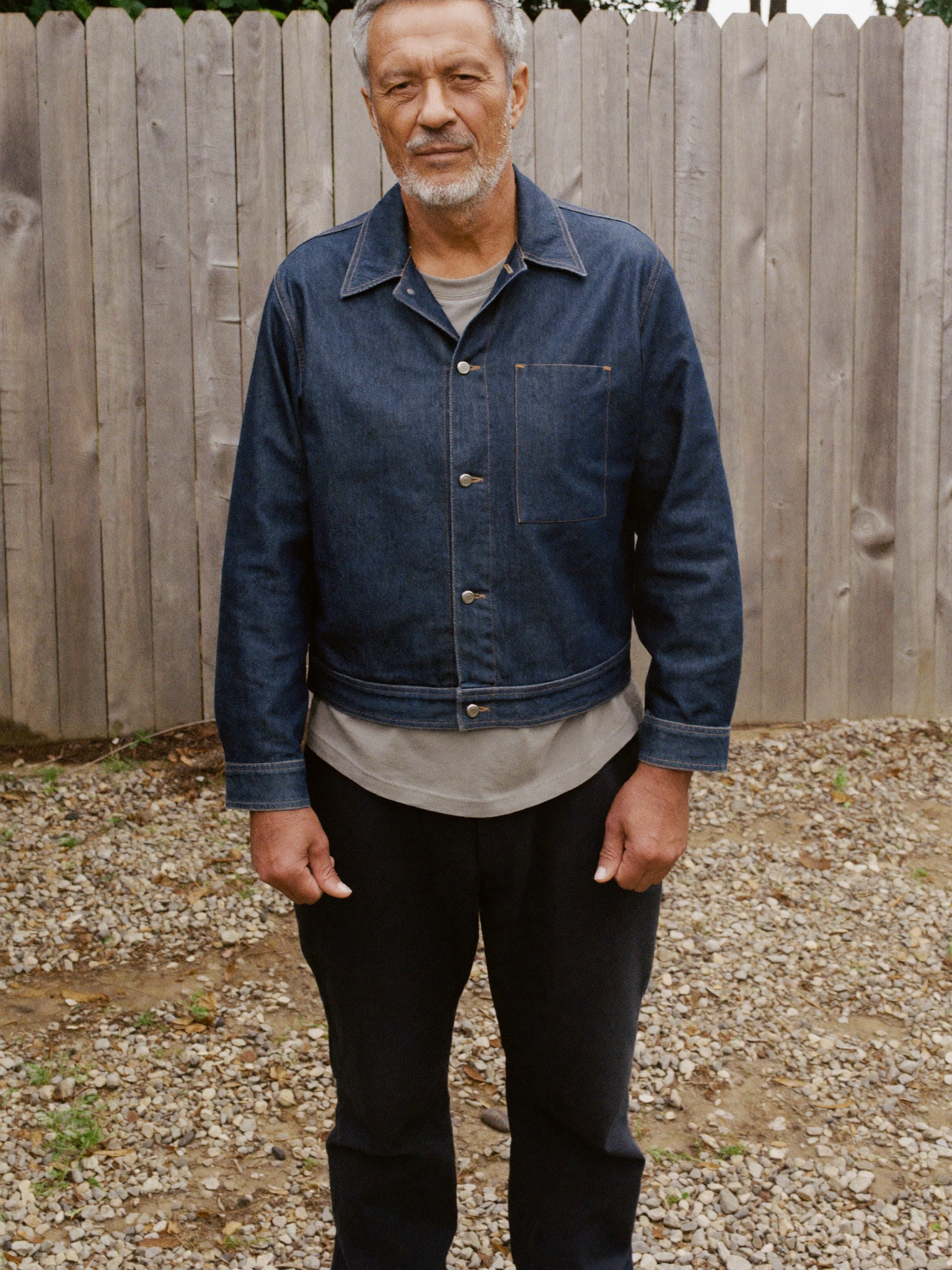 Full-length view of a man wearing an indigo denim jacket, showing the cut and length